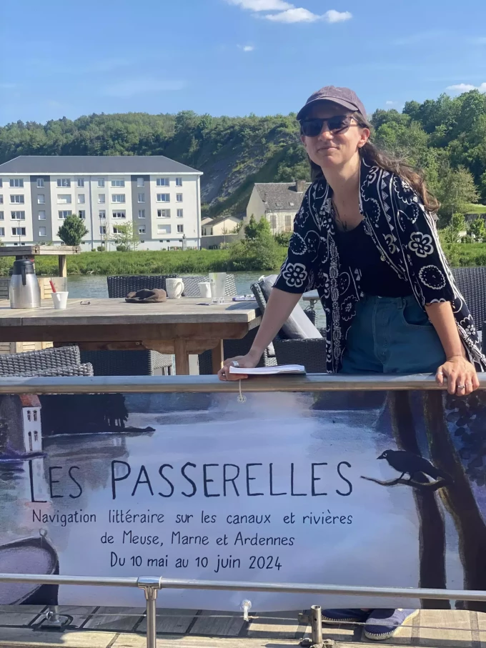 Claire derri&egrave;re la grande b&acirc;che "Les Passerelles" illustr&eacute;e par Anne Brouillard
